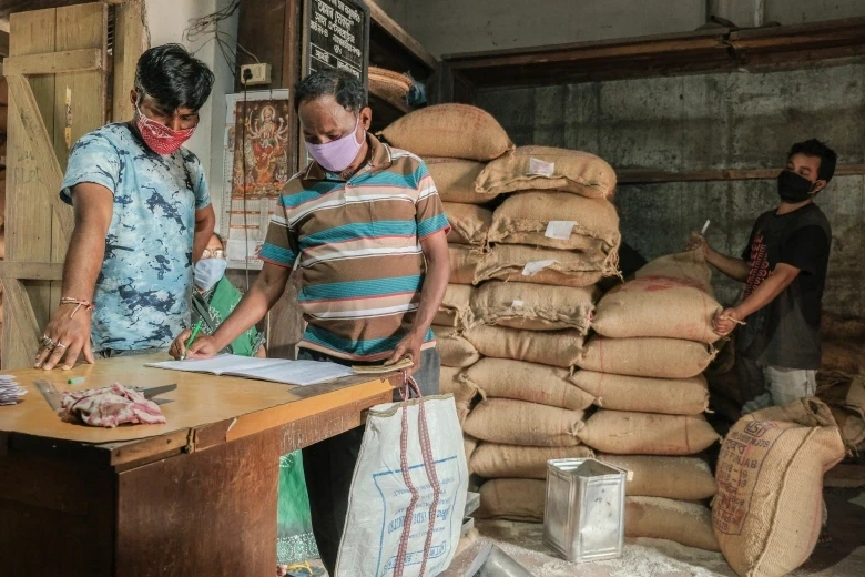 People collecting rations from a distribution center, illustrating the benefits of different types of ration cards"
