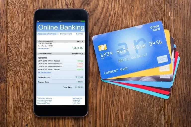 Account Balance Check In Union Bank Of India Via ATM Online banking and credit cards neatly arranged on a table means
