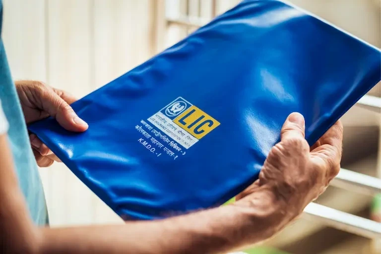 Benefits of Becoming an LIC Agent 1. A man stands holding a blue bag, which is covered in a matching blue fabric, showcasing Benefits of Becoming an LIC Agent