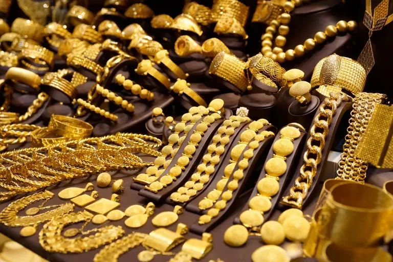 Types of Gold Jewellery Gold jewelry and coins showcased on a table show to different types of gold